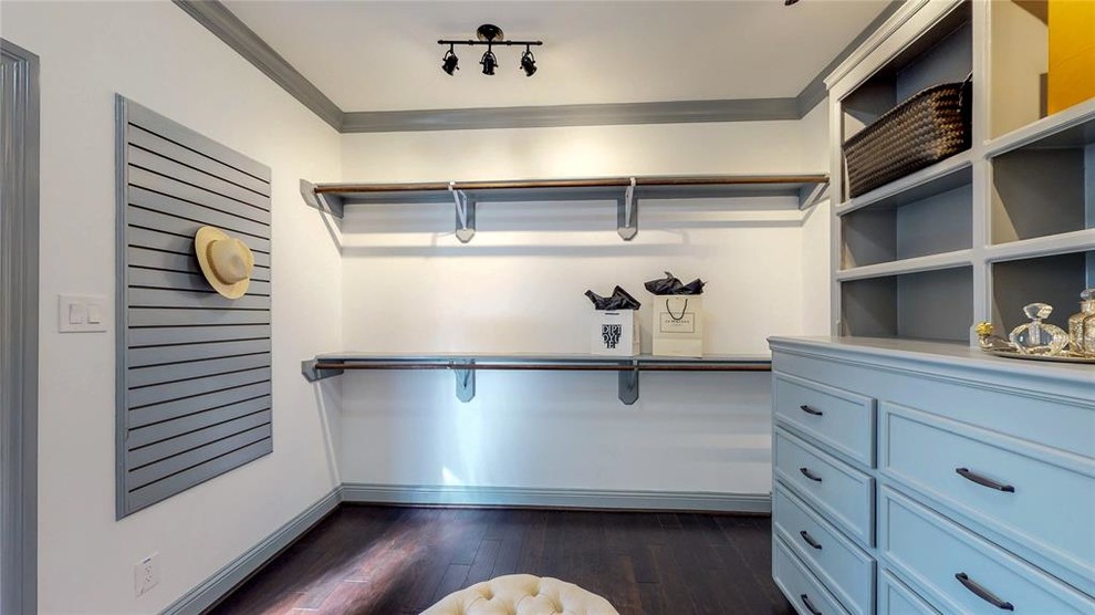 This is an example of a large modern gender-neutral walk-in wardrobe in Houston with shaker cabinets, grey cabinets, laminate floors and brown floor.