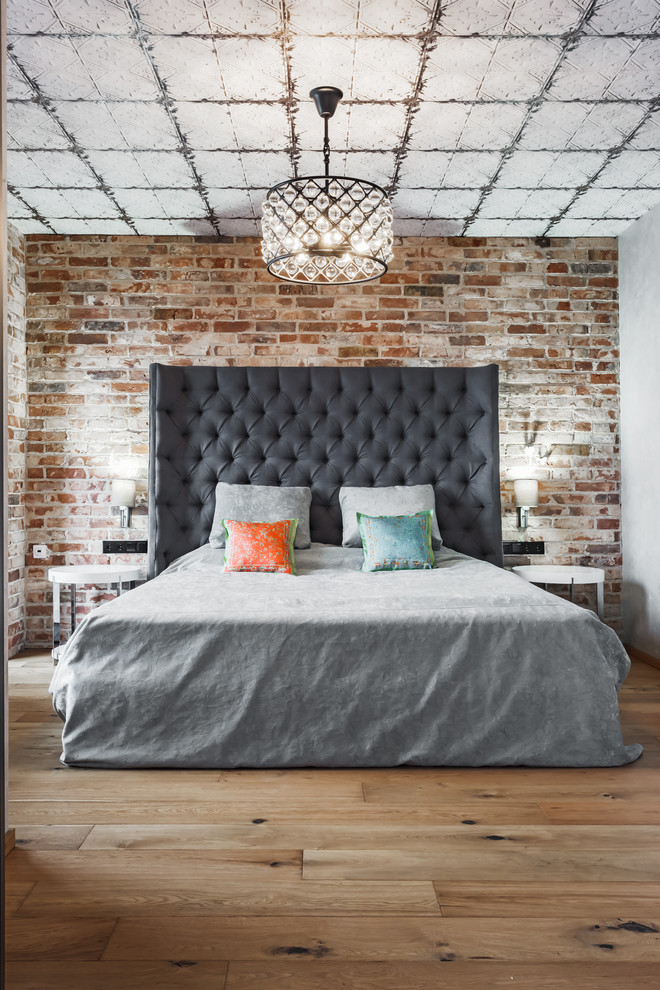 This is an example of an industrial guest bedroom in Other with medium hardwood floors and brown floor.