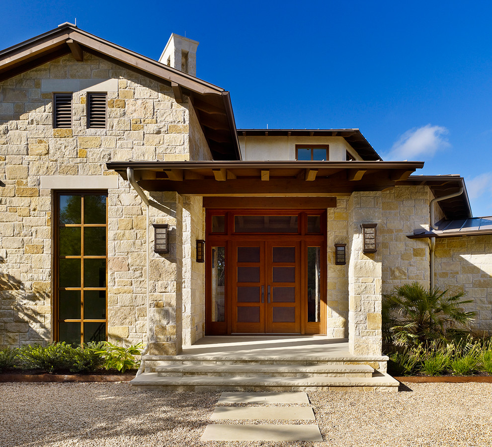 Photo of a mid-sized country front door in Austin with a double front door and a medium wood front door.