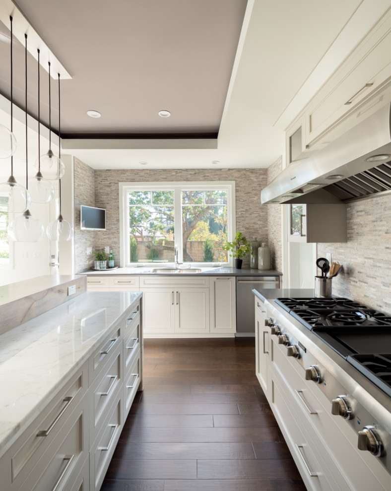 Mid-sized transitional u-shaped separate kitchen in Los Angeles with a double-bowl sink, shaker cabinets, white cabinets, quartz benchtops, grey splashback, matchstick tile splashback, stainless steel appliances, dark hardwood floors and with island.