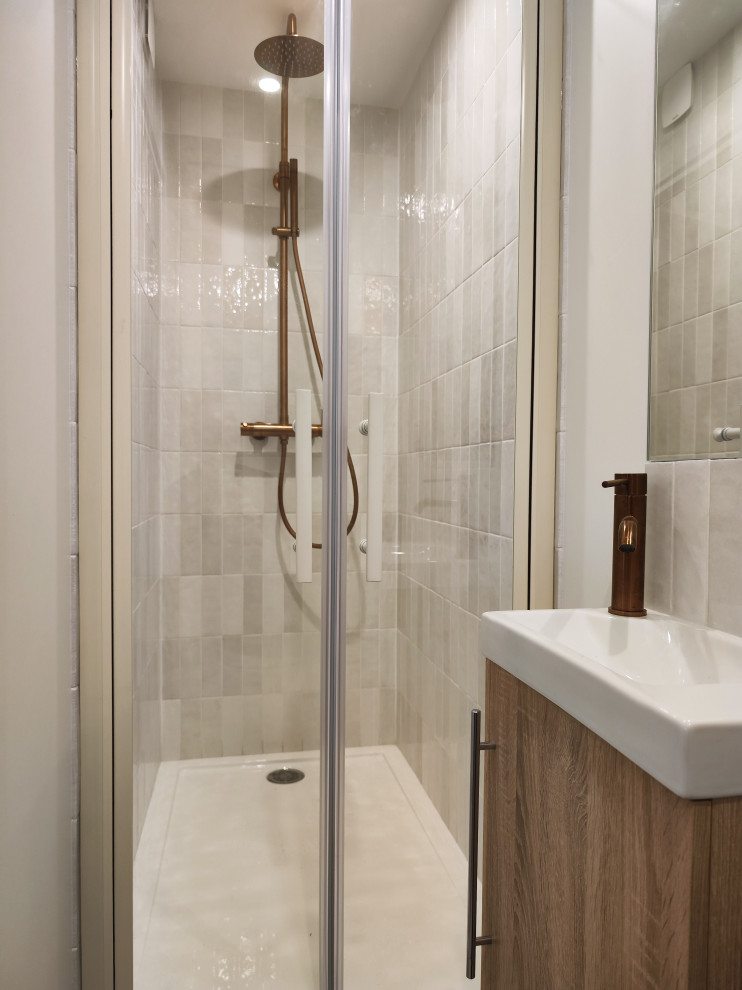 Inspiration för små moderna vitt badrum med dusch, med luckor med profilerade fronter, grå skåp, en kantlös dusch, en vägghängd toalettstol, vit kakel, keramikplattor, vita väggar, klinkergolv i keramik, ett undermonterad handfat, bänkskiva i kvarts, grått golv och dusch med gångjärnsdörr