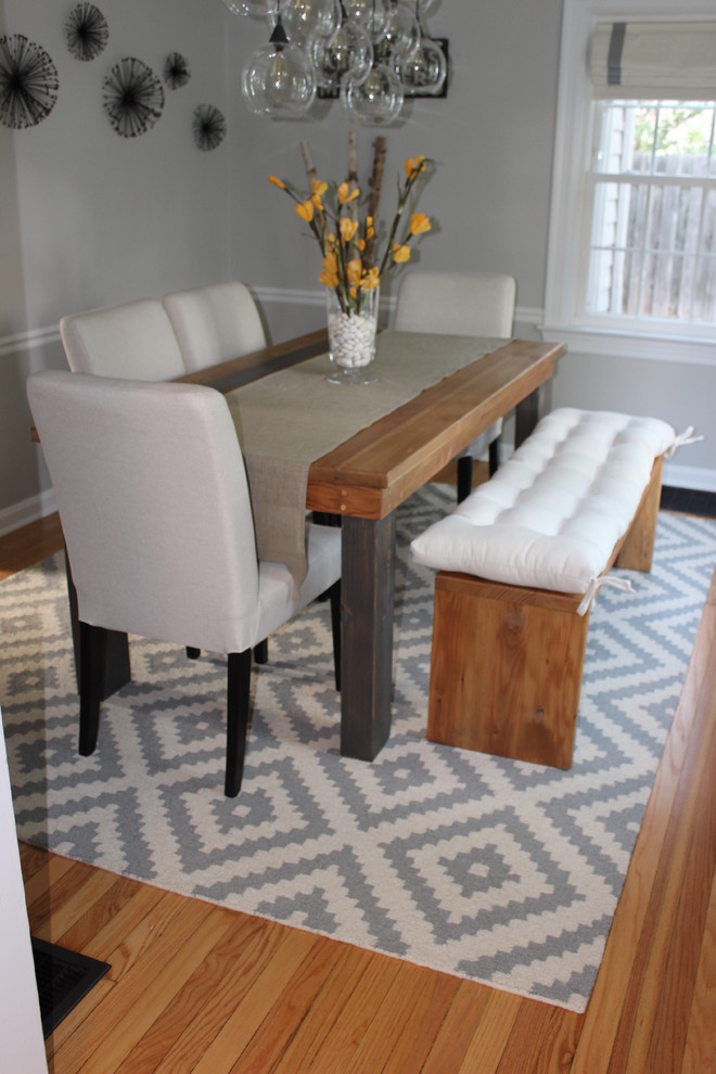 This is an example of a small eclectic separate dining room in Indianapolis with grey walls, medium hardwood floors and no fireplace.