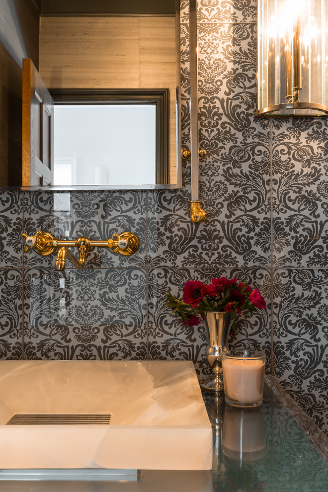 Eclectic powder room in New York with a vessel sink, gray tile and glass tile.