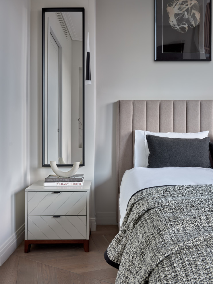 This is an example of a contemporary master bedroom in Moscow with white walls, light hardwood floors and beige floor.