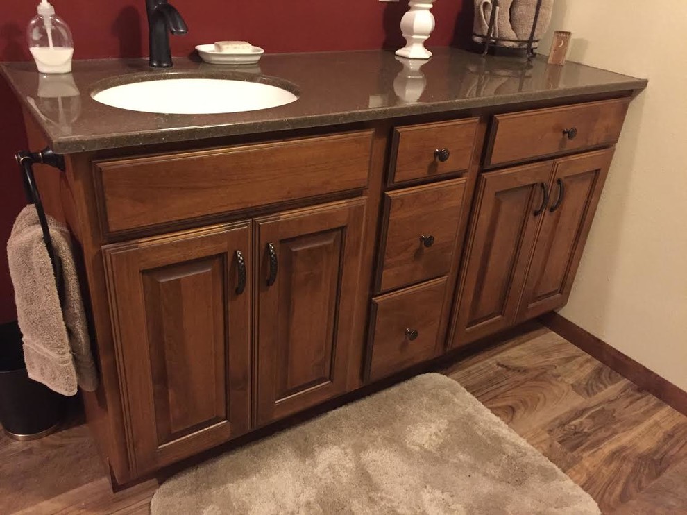 Photo of a country bathroom in Other with raised-panel cabinets, brown cabinets, red walls and onyx benchtops.