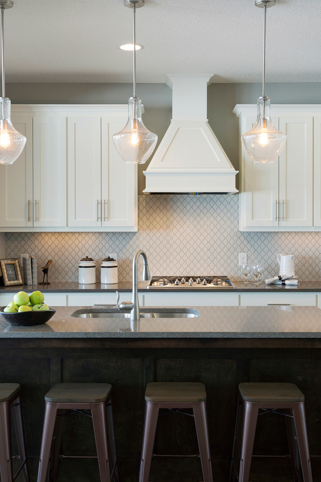 Kitchen - transitional dark wood floor kitchen idea in Minneapolis with a double-bowl sink, white cabinets, quartzite countertops, white backsplash, ceramic backsplash, stainless steel appliances and an island