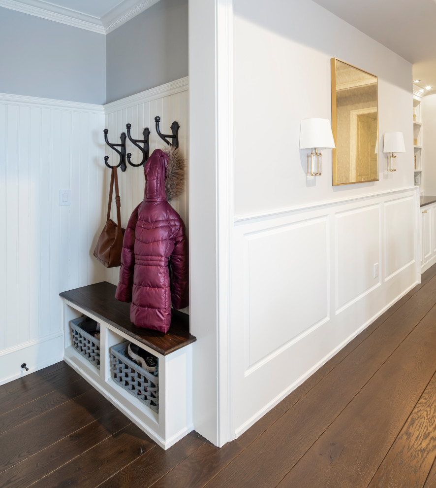 This is an example of a small transitional entryway in Other with dark hardwood floors, brown floor and panelled walls.