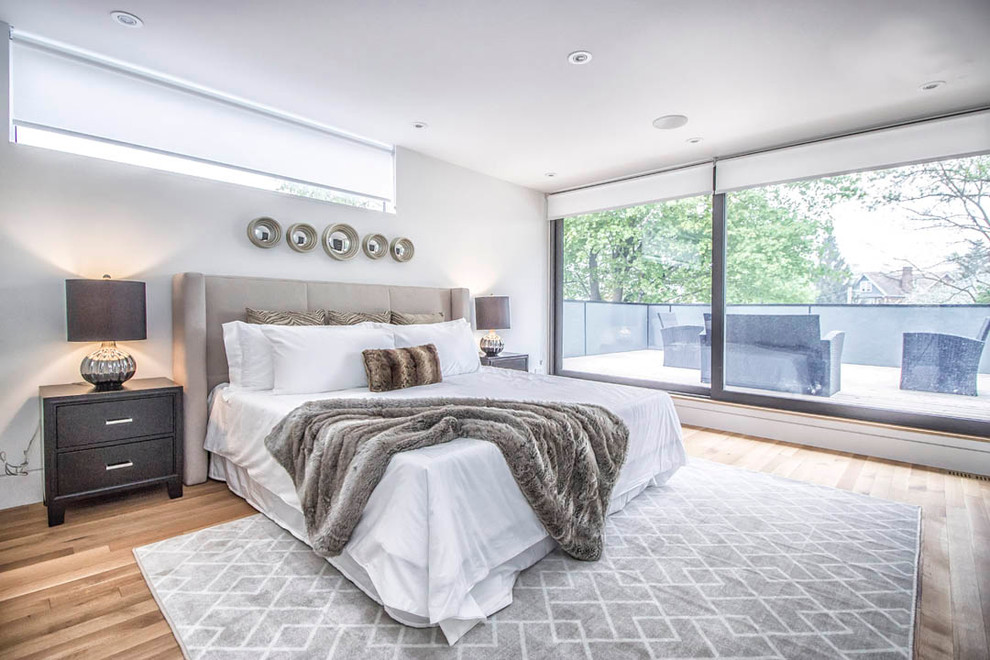 Mid-sized modern guest bedroom in Toronto with white walls, light hardwood floors and no fireplace.