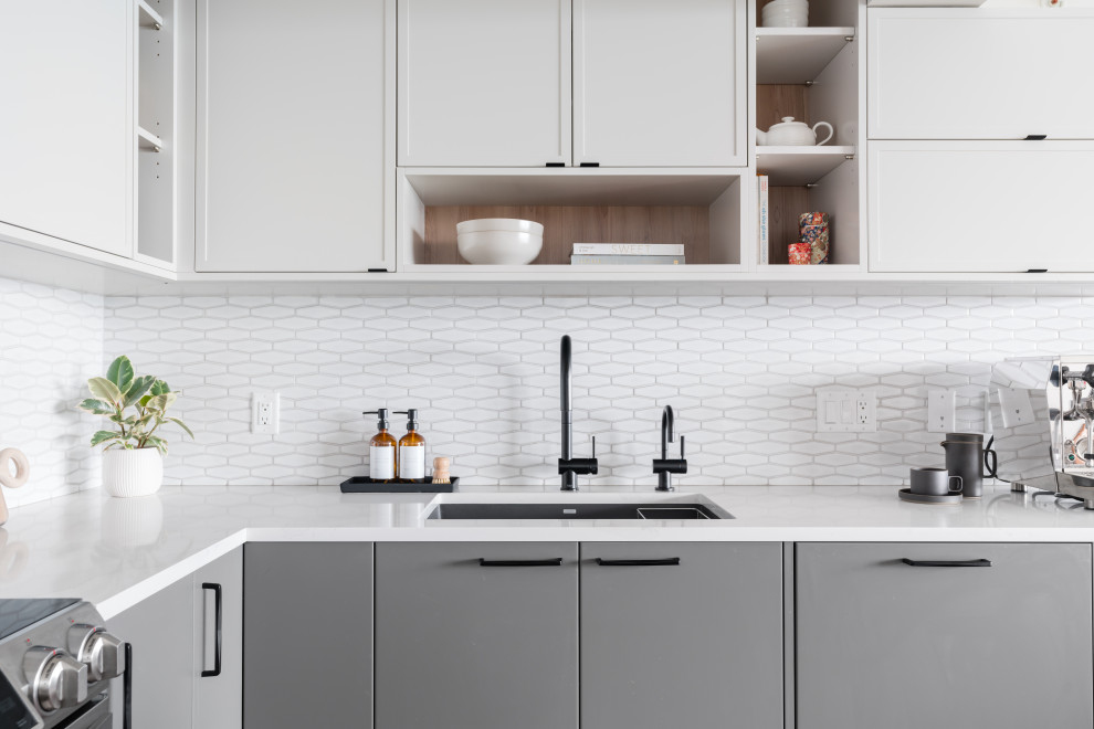 Example of a mid-sized trendy l-shaped medium tone wood floor and brown floor eat-in kitchen design in Vancouver with an undermount sink, shaker cabinets, white cabinets, quartz countertops, white backsplash, porcelain backsplash, stainless steel appliances, an island and white countertops