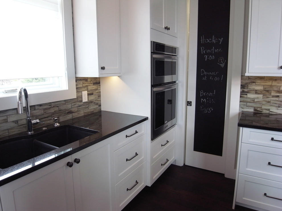 Open concept kitchen - transitional open concept kitchen idea with white cabinets, stainless steel appliances, an island and flat-panel cabinets