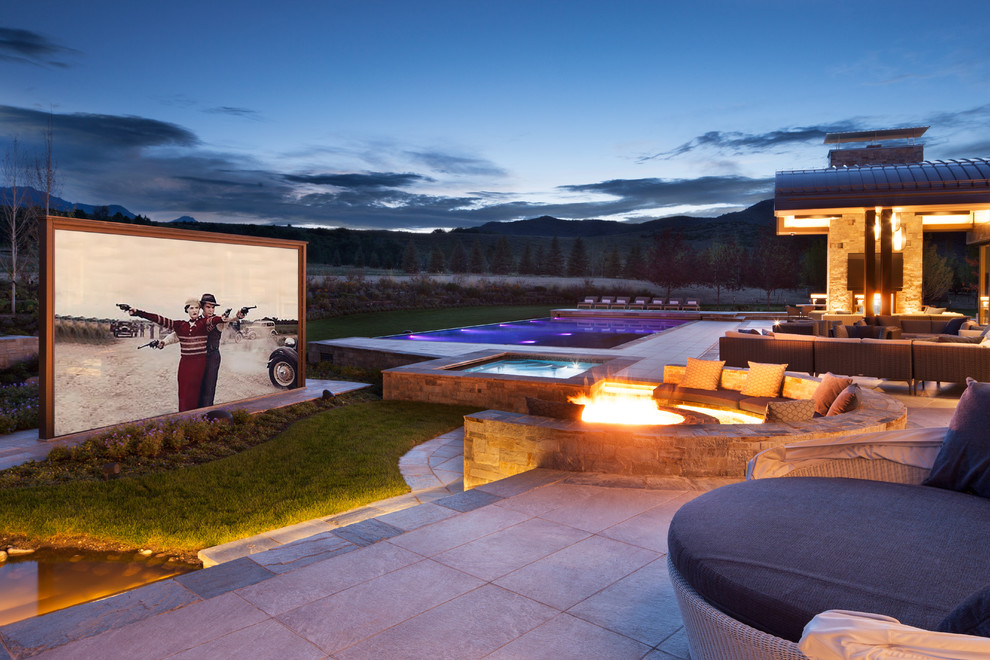 Photo of an expansive contemporary backyard patio in Denver with a fire feature, tile and a roof extension.