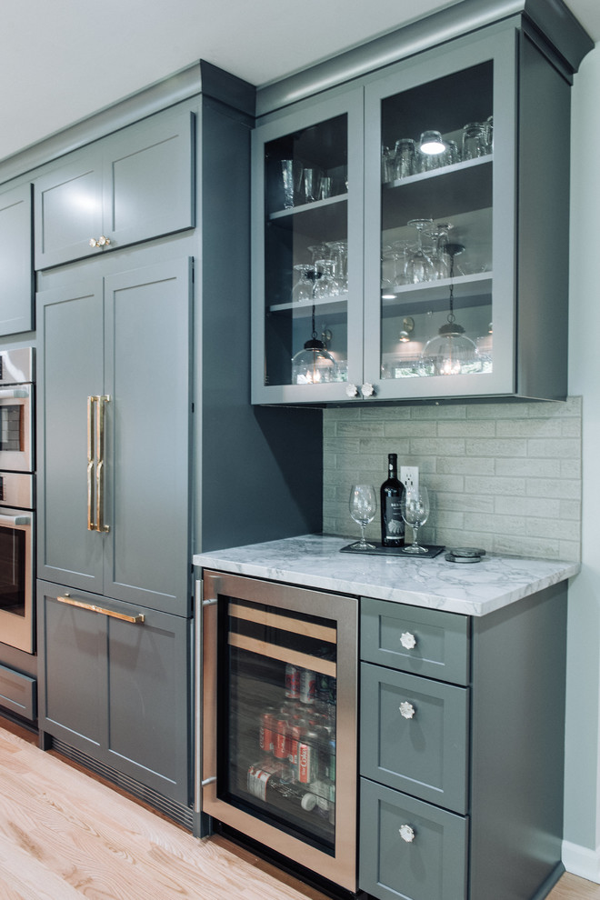 Mid-sized modern single-wall kitchen pantry in Detroit with an undermount sink, shaker cabinets, grey cabinets, quartzite benchtops, yellow splashback, porcelain splashback, panelled appliances, light hardwood floors, with island, beige floor and grey benchtop.