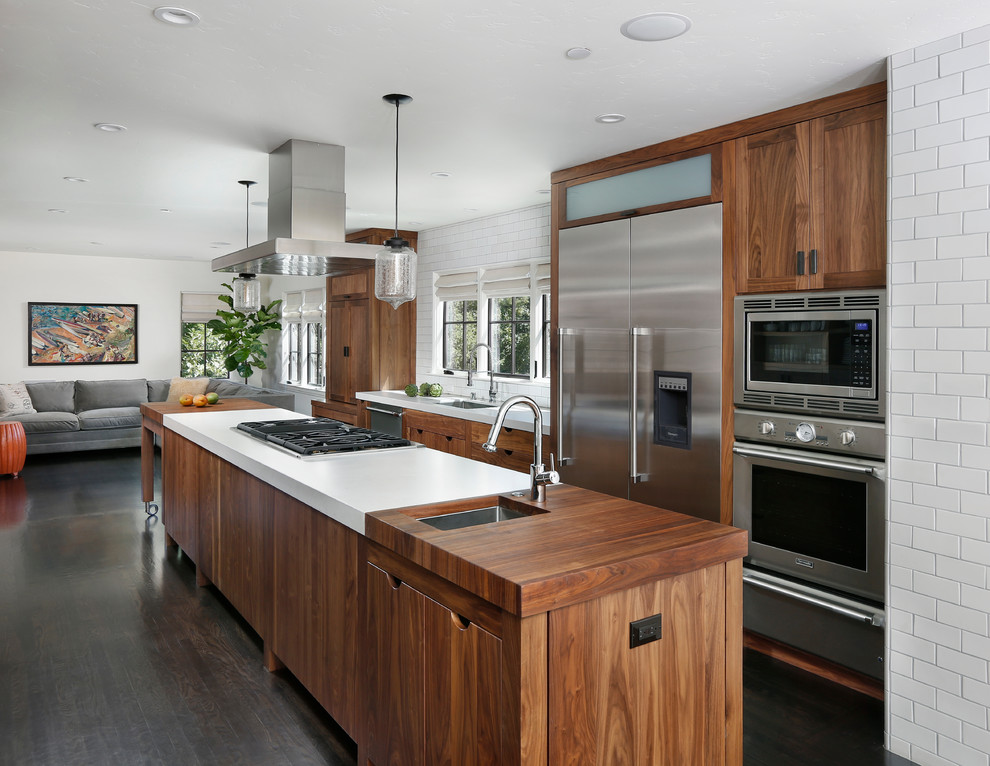 This is an example of a contemporary galley kitchen in San Francisco with stainless steel appliances, wood benchtops and dark wood cabinets.