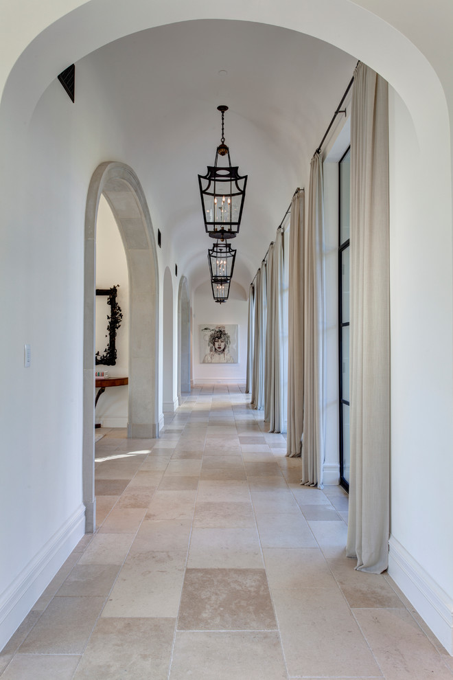 Design ideas for an expansive mediterranean hallway in Dallas with white walls and limestone floors.