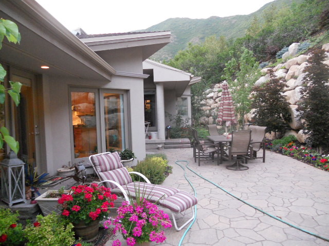This is an example of a large contemporary back patio in Salt Lake City with natural stone paving.