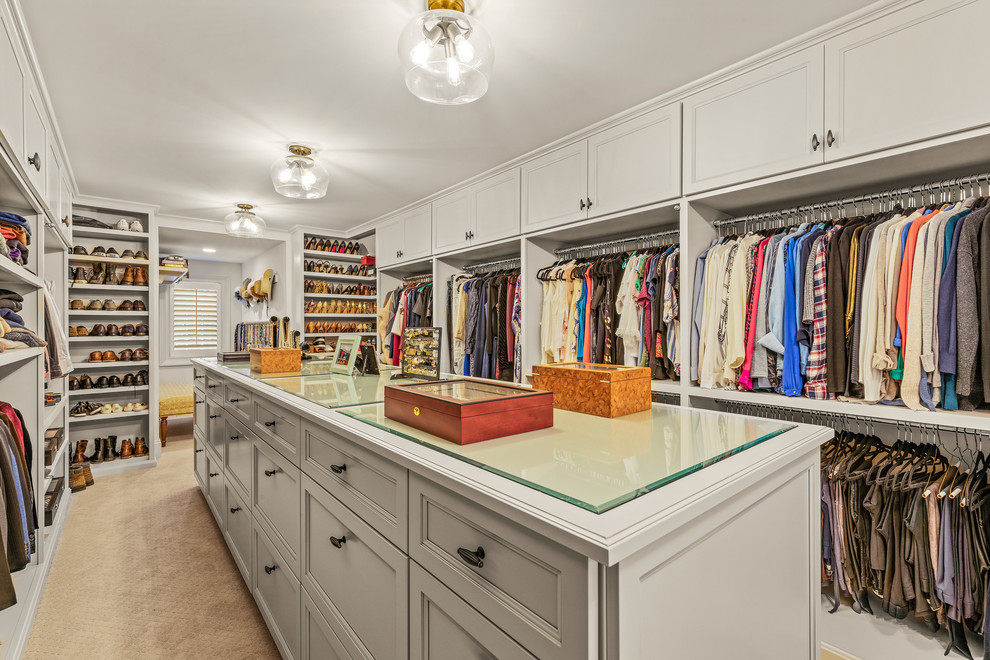 Photo of a large traditional gender-neutral walk-in wardrobe in Cleveland with recessed-panel cabinets, white cabinets, carpet and beige floor.
