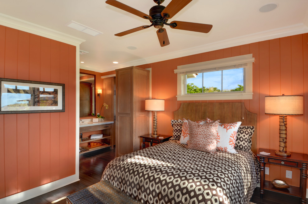 Tropical master bedroom in Hawaii with orange walls and dark hardwood floors.