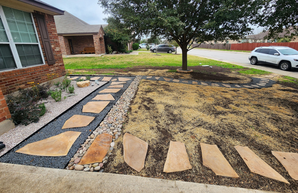 Small contemporary front yard partial sun xeriscape in Austin with with path and natural stone pavers for fall.