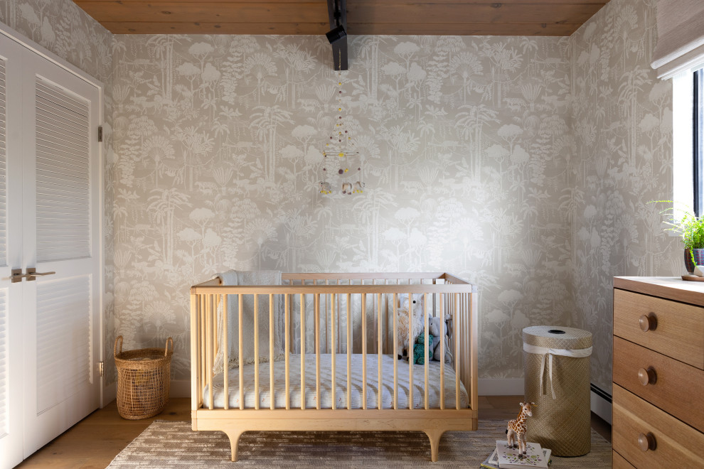 Cette image montre une chambre de bébé garçon vintage de taille moyenne avec un mur beige, parquet clair, un sol beige, poutres apparentes et du papier peint.