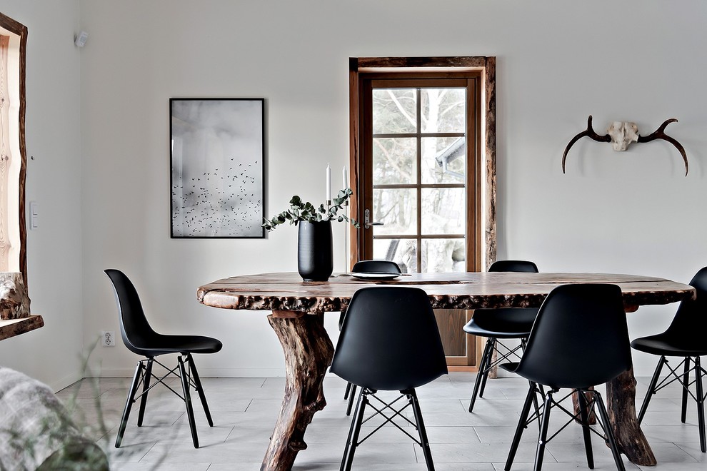 This is an example of a mid-sized country separate dining room in Malmo with white walls and ceramic floors.