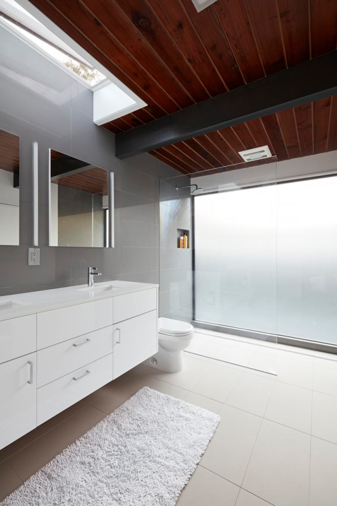 Large midcentury master bathroom in San Francisco with flat-panel cabinets, white cabinets, an open shower, a two-piece toilet, gray tile, porcelain tile, porcelain floors, an undermount sink, beige floor, an open shower, white benchtops, a niche, a double vanity, a floating vanity and wood.