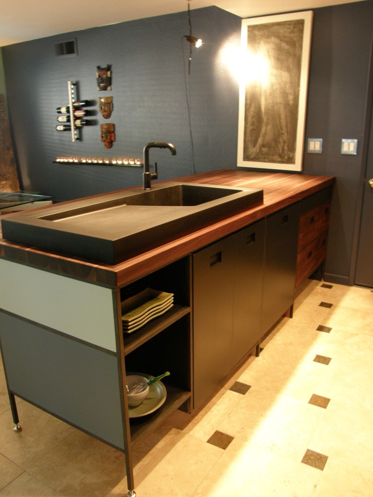 This is an example of an industrial kitchen in Orange County with a single-bowl sink, wood benchtops and travertine floors.