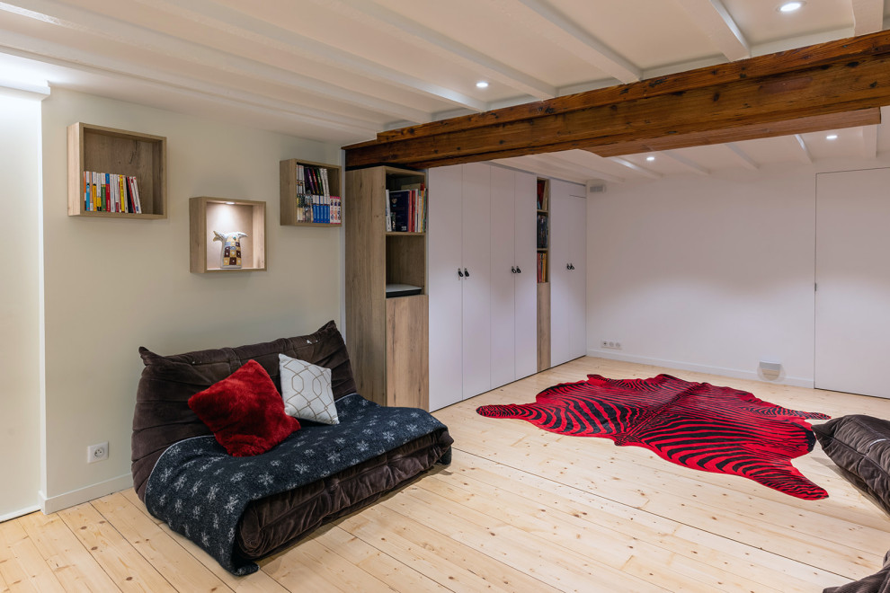 Foto de cine en casa industrial con suelo de madera clara y pared multimedia
