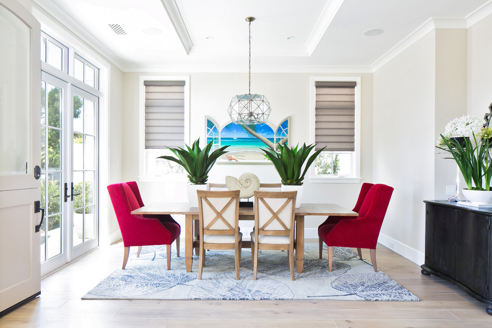 This is an example of a beach style separate dining room in Orange County with beige walls and light hardwood floors.