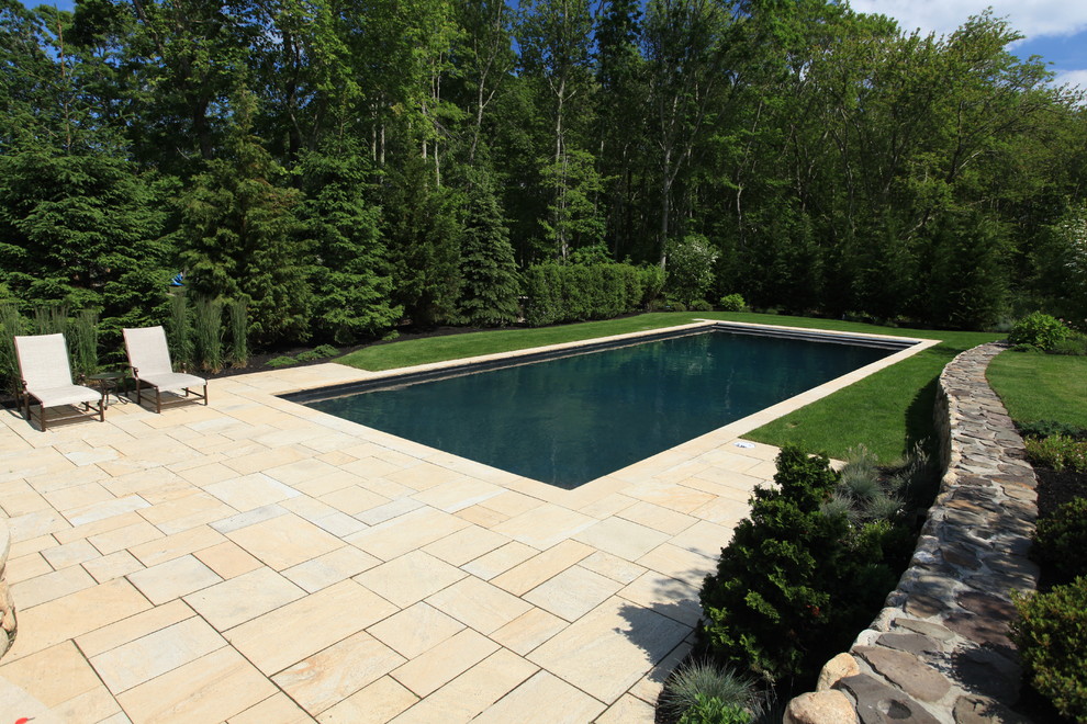 Design ideas for a large country backyard pool in Boston with concrete pavers.