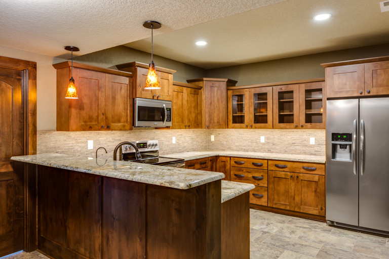 Mountain style u-shaped eat-in kitchen photo with an undermount sink, shaker cabinets and an island