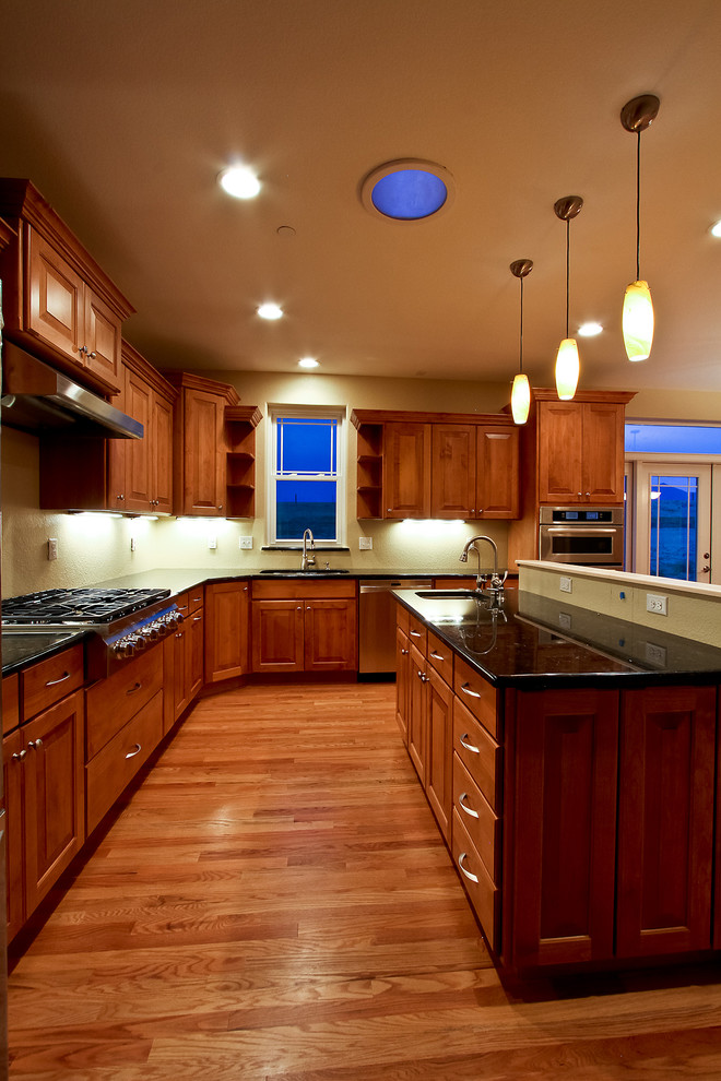 Eat-in kitchen - transitional l-shaped eat-in kitchen idea in Denver with an undermount sink, raised-panel cabinets, medium tone wood cabinets, granite countertops and stainless steel appliances