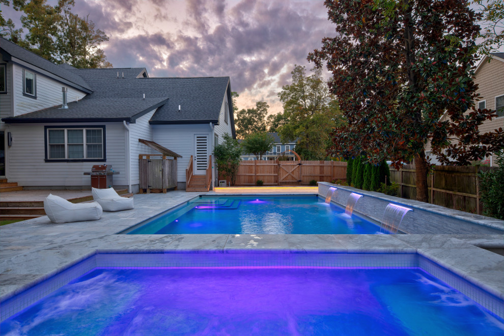 Ispirazione per una grande piscina contemporanea rettangolare dietro casa con una vasca idromassaggio e pavimentazioni in pietra naturale