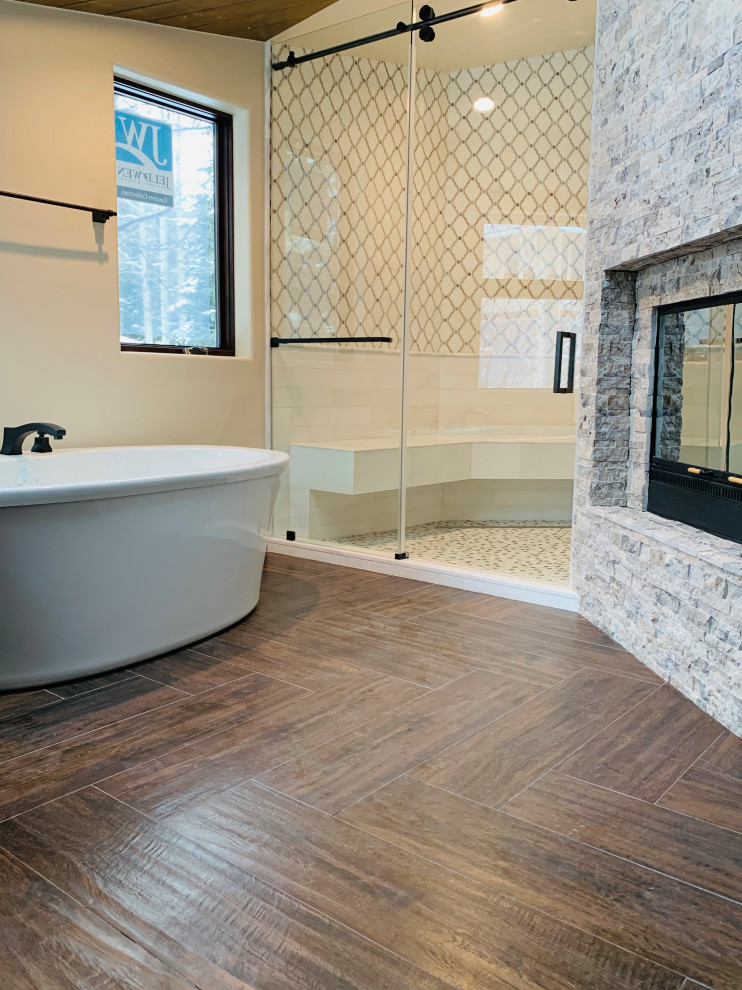 Large traditional ensuite bathroom in Denver with a freestanding bath, an alcove shower, white tiles, marble tiles, white walls, wood-effect flooring, granite worktops, brown floors, a sliding door, a shower bench, a freestanding vanity unit and a wood ceiling.