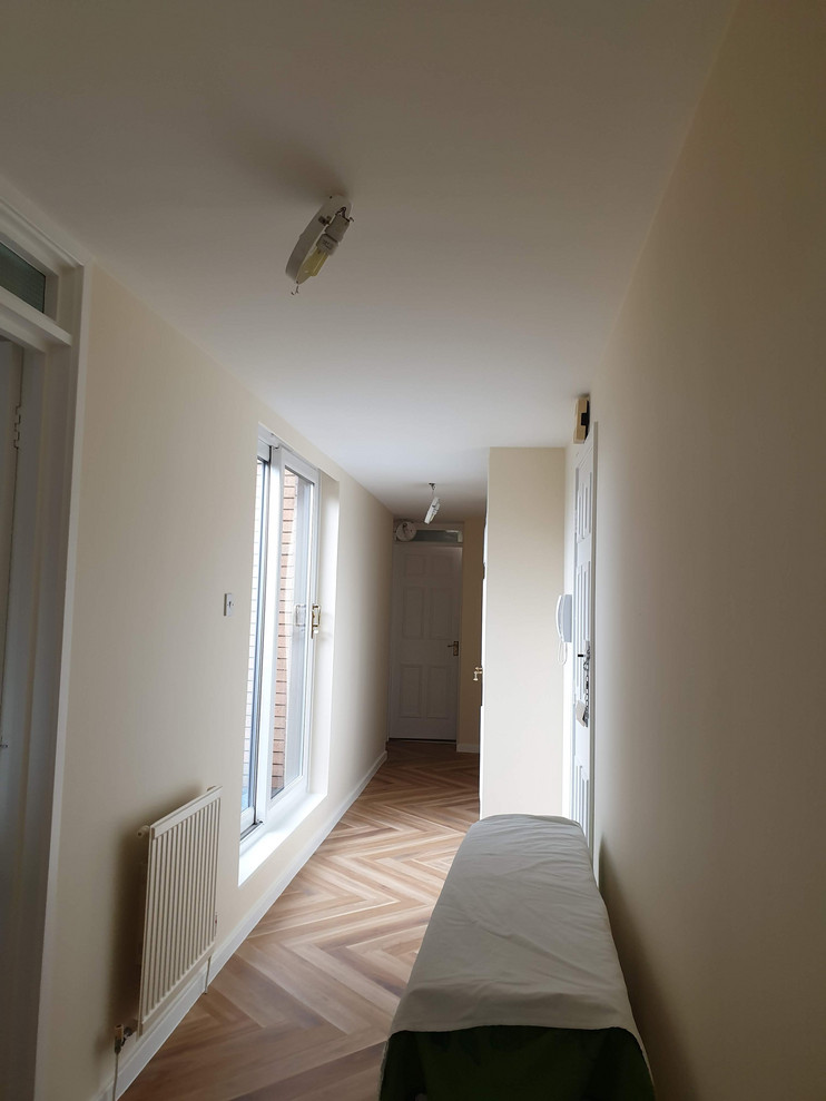 Foto di una grande camera degli ospiti minimalista con pareti beige, moquette, pavimento marrone e soffitto ribassato