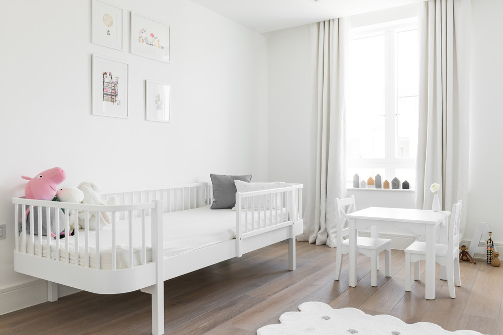 This is an example of a large scandinavian kids' room for girls in London with white walls.