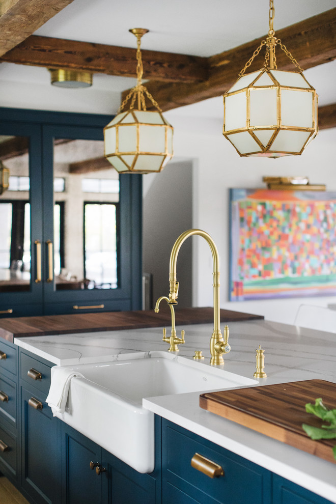 Inspiration for a mid-sized transitional galley medium tone wood floor and brown floor eat-in kitchen remodel in Grand Rapids with a farmhouse sink, shaker cabinets, blue cabinets, quartz countertops and an island