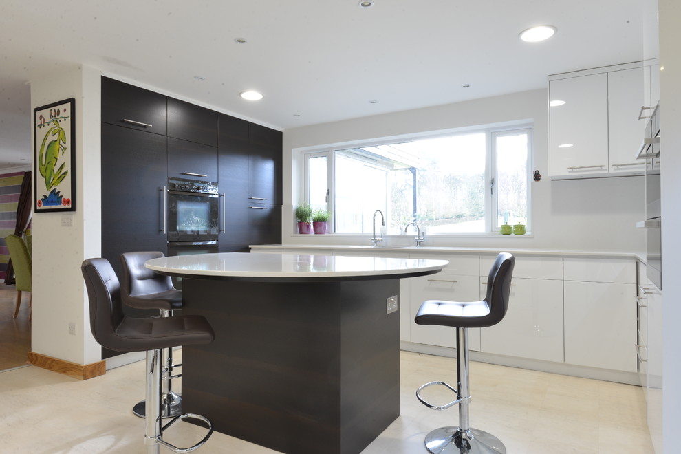 Mid-sized contemporary u-shaped open plan kitchen in Cambridgeshire with an undermount sink, flat-panel cabinets, white cabinets, quartzite benchtops, white splashback, ceramic floors and with island.