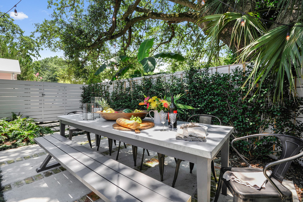 Contemporary backyard patio in New Orleans with concrete slab and no cover.