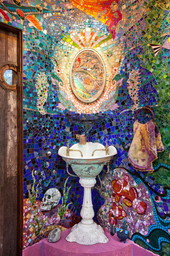 This is an example of an eclectic powder room in San Francisco with a pedestal sink, multi-coloured tile, mosaic tile and pink floor.