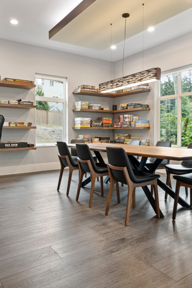 Exemple d'une salle à manger ouverte sur la cuisine moderne de taille moyenne avec un mur gris, un sol en vinyl, un sol gris et un plafond voûté.