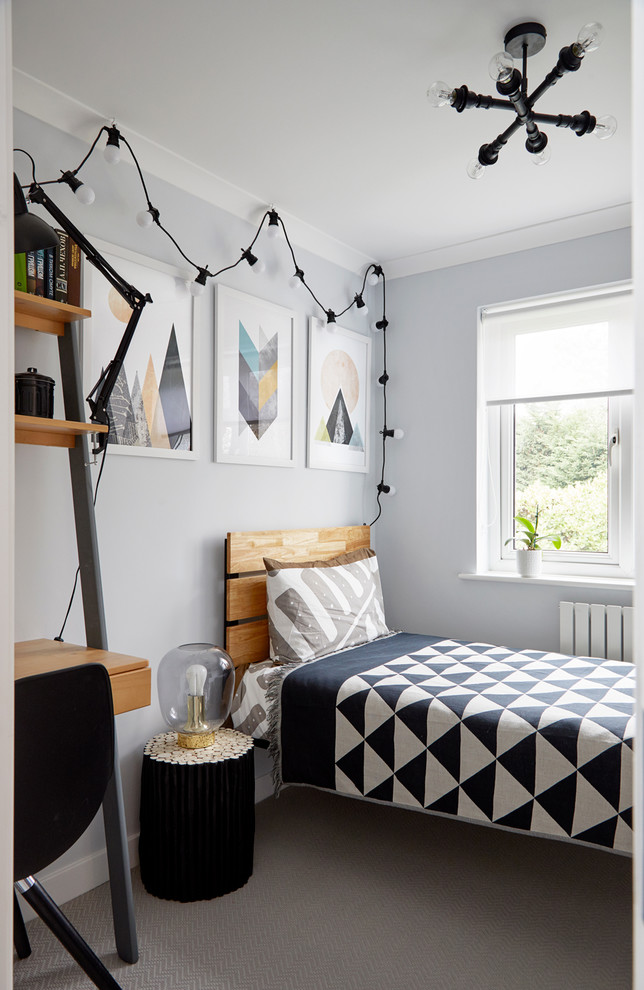 This is an example of a transitional kids' room for boys in London with grey walls, carpet and grey floor.