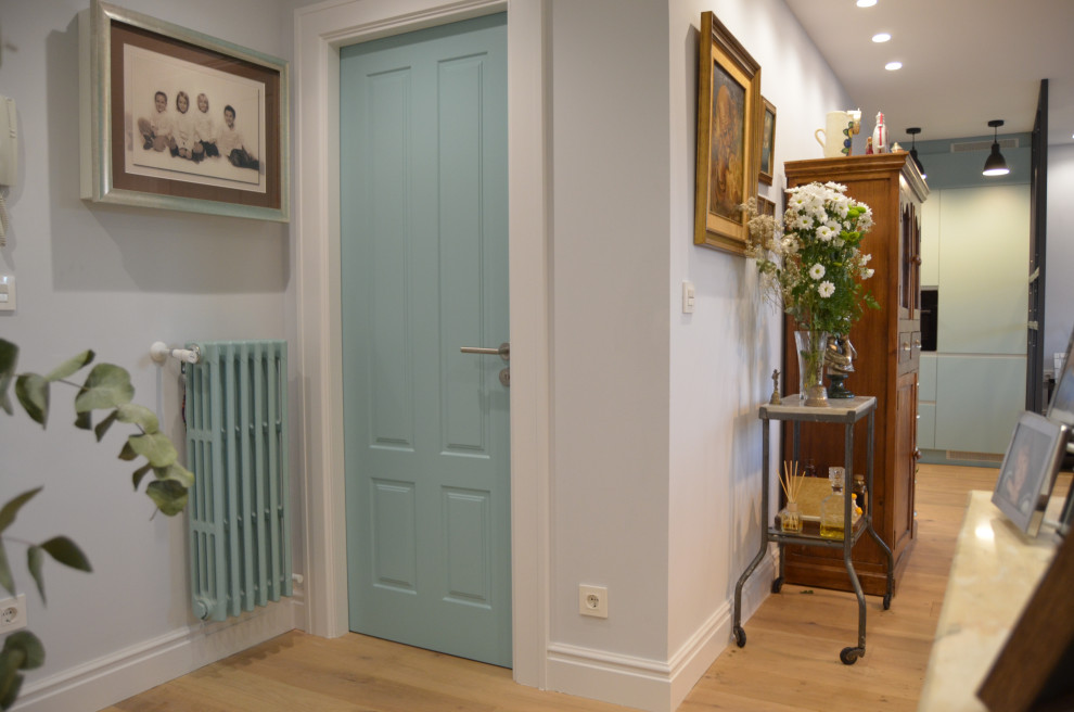 Foto de recibidores y pasillos tradicionales renovados de tamaño medio con paredes azules, suelo de madera clara, suelo marrón y papel pintado