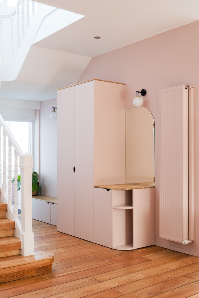 This is an example of a large scandinavian entryway in Lille with pink walls and medium hardwood floors.