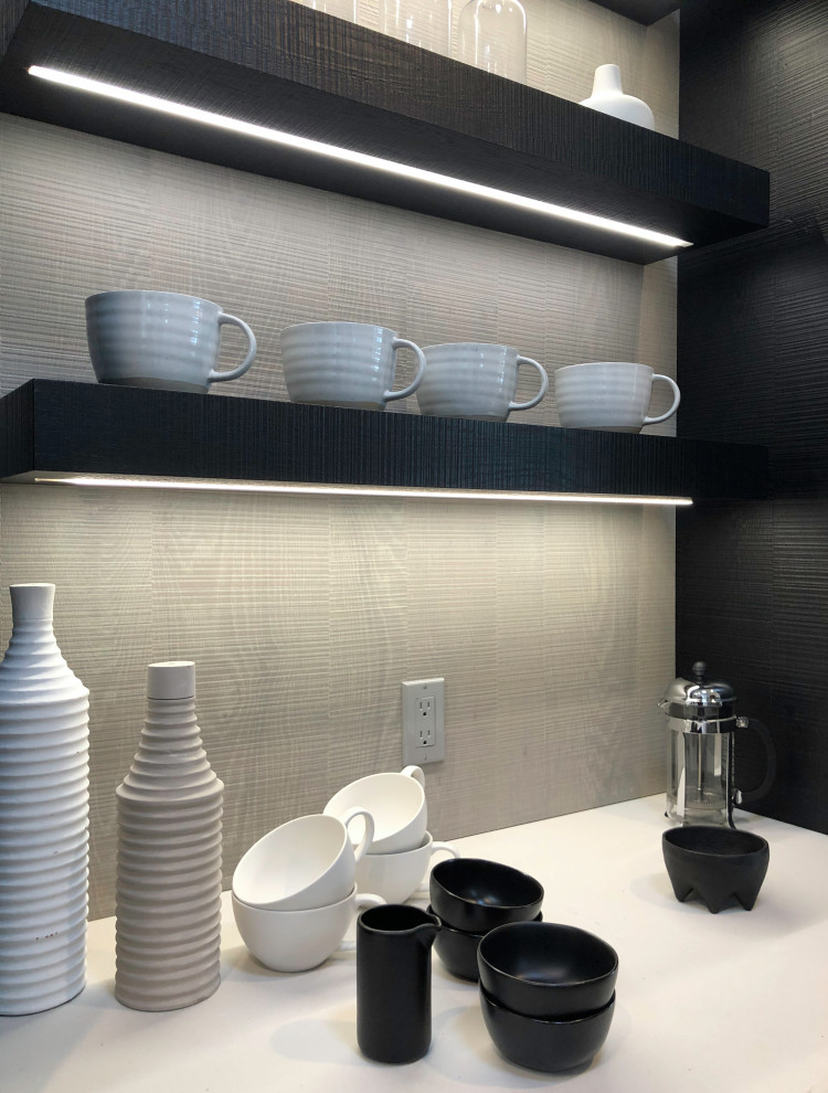 Photo of a large contemporary single-wall dry bar in New York with black cabinets, grey splashback, light hardwood flooring, beige floors, white worktops, floating shelves and quartz worktops.