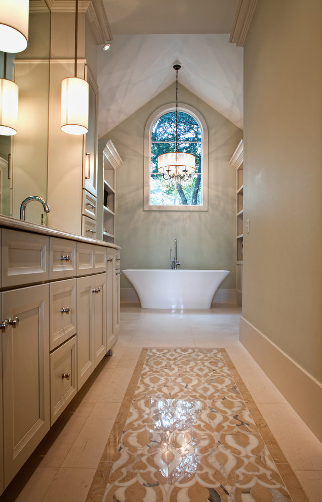 This is an example of a mid-sized traditional master bathroom in Charleston with a freestanding tub, beige walls, marble floors, marble benchtops, recessed-panel cabinets, beige cabinets and an undermount sink.