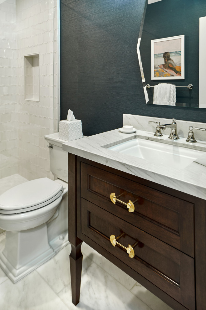 Inspiration for a small transitional 3/4 bathroom in San Francisco with beaded inset cabinets, brown cabinets, an alcove shower, a two-piece toilet, white tile, ceramic tile, blue walls, marble floors, an undermount sink, marble benchtops, white floor, a hinged shower door, white benchtops, a single vanity, a freestanding vanity and wallpaper.