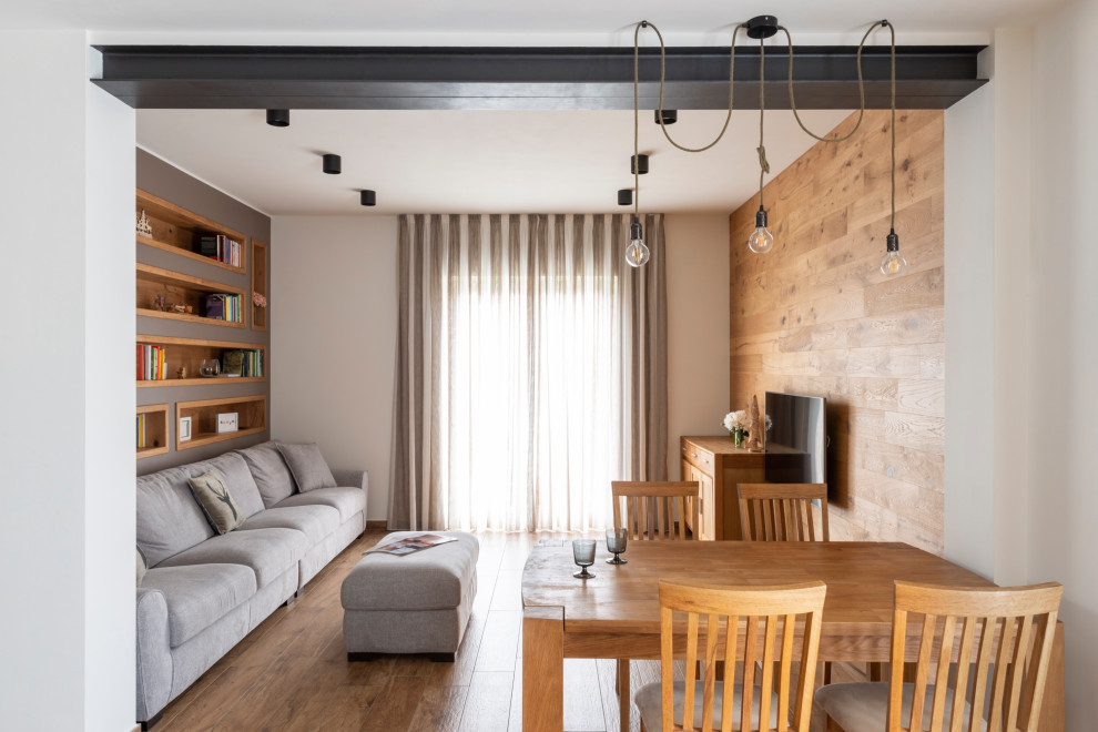 Inspiration for a small country open concept living room in Milan with a library, grey walls, porcelain floors, no fireplace, a wall-mounted tv and brown floor.