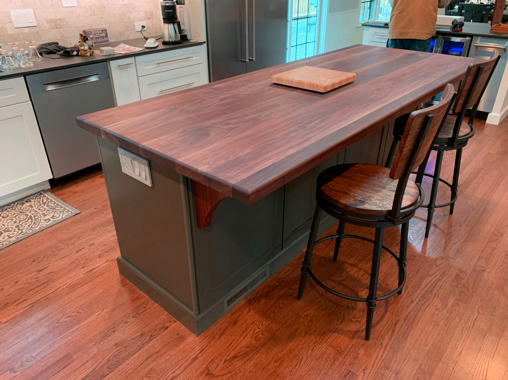 Large contemporary galley eat-in kitchen in Chicago with an integrated sink, wood benchtops, stainless steel appliances, medium hardwood floors, with island and brown benchtop.