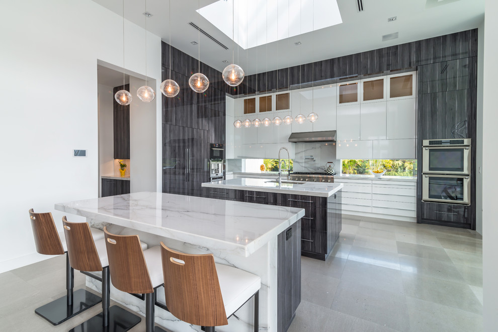 Large contemporary l-shaped eat-in kitchen in Miami with an undermount sink, flat-panel cabinets, white cabinets, stainless steel appliances and multiple islands.