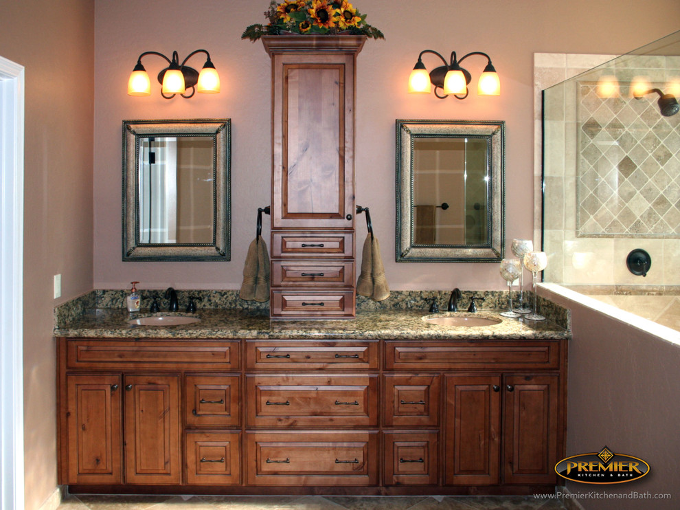 Inspiration for a large traditional master bathroom in Phoenix with raised-panel cabinets, medium wood cabinets, granite benchtops, an alcove shower, beige tile, stone tile, beige walls and porcelain floors.